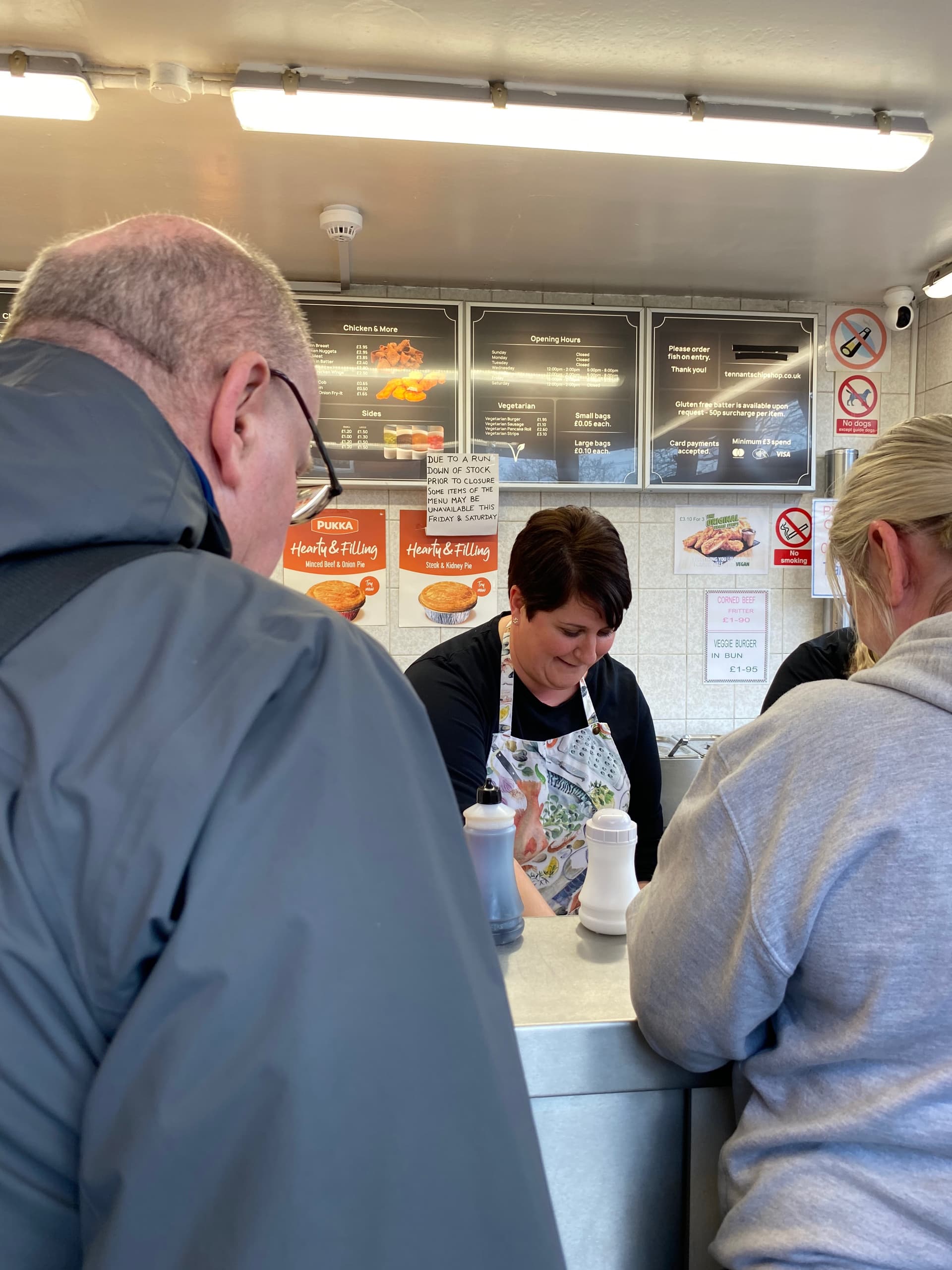 Photo of Karen Tennant serving two customers.