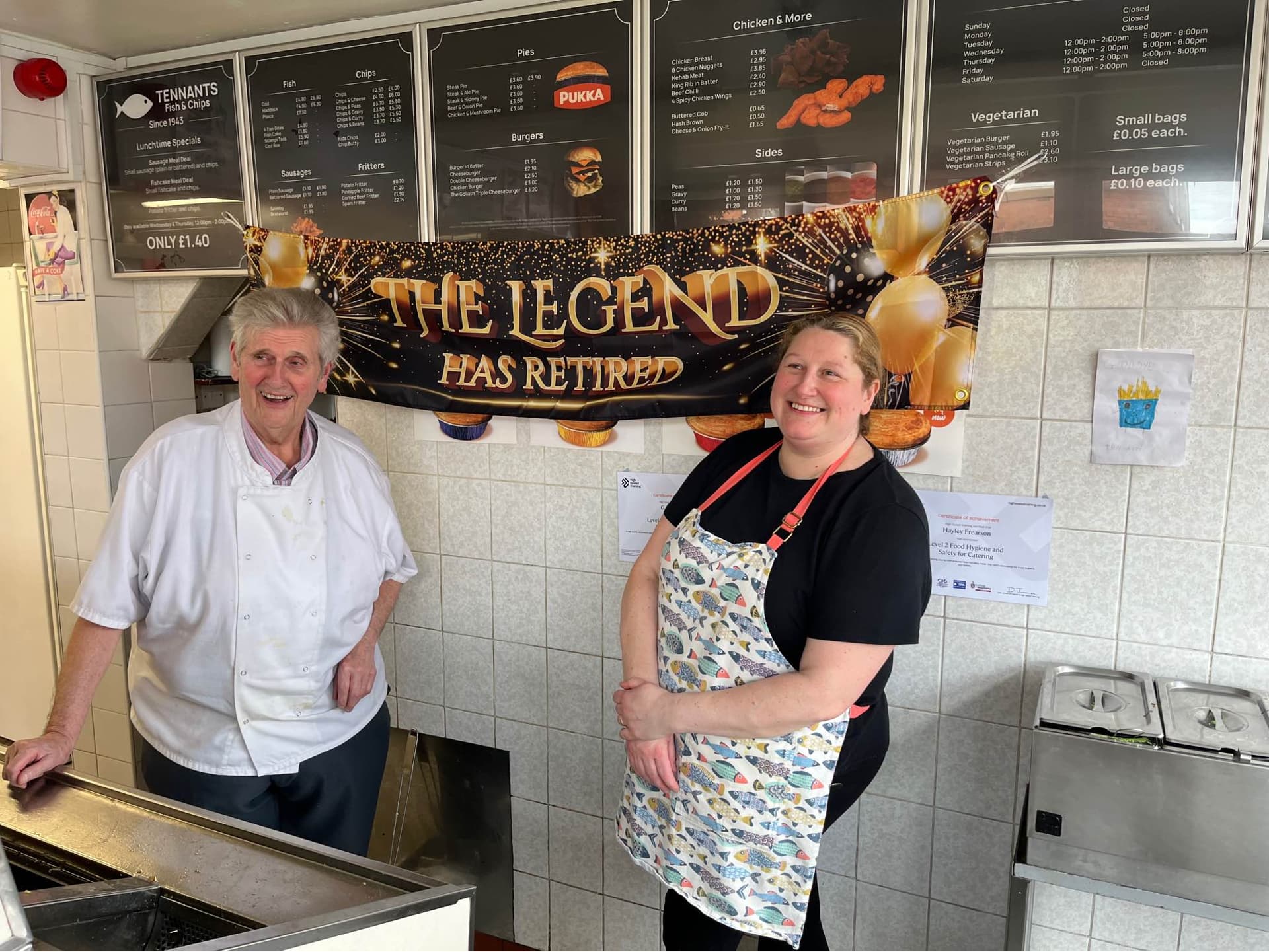 A photo of Gary Tennant and Hayley Frearson standing in front of a banner, stating 'The Legend Has Retired'.