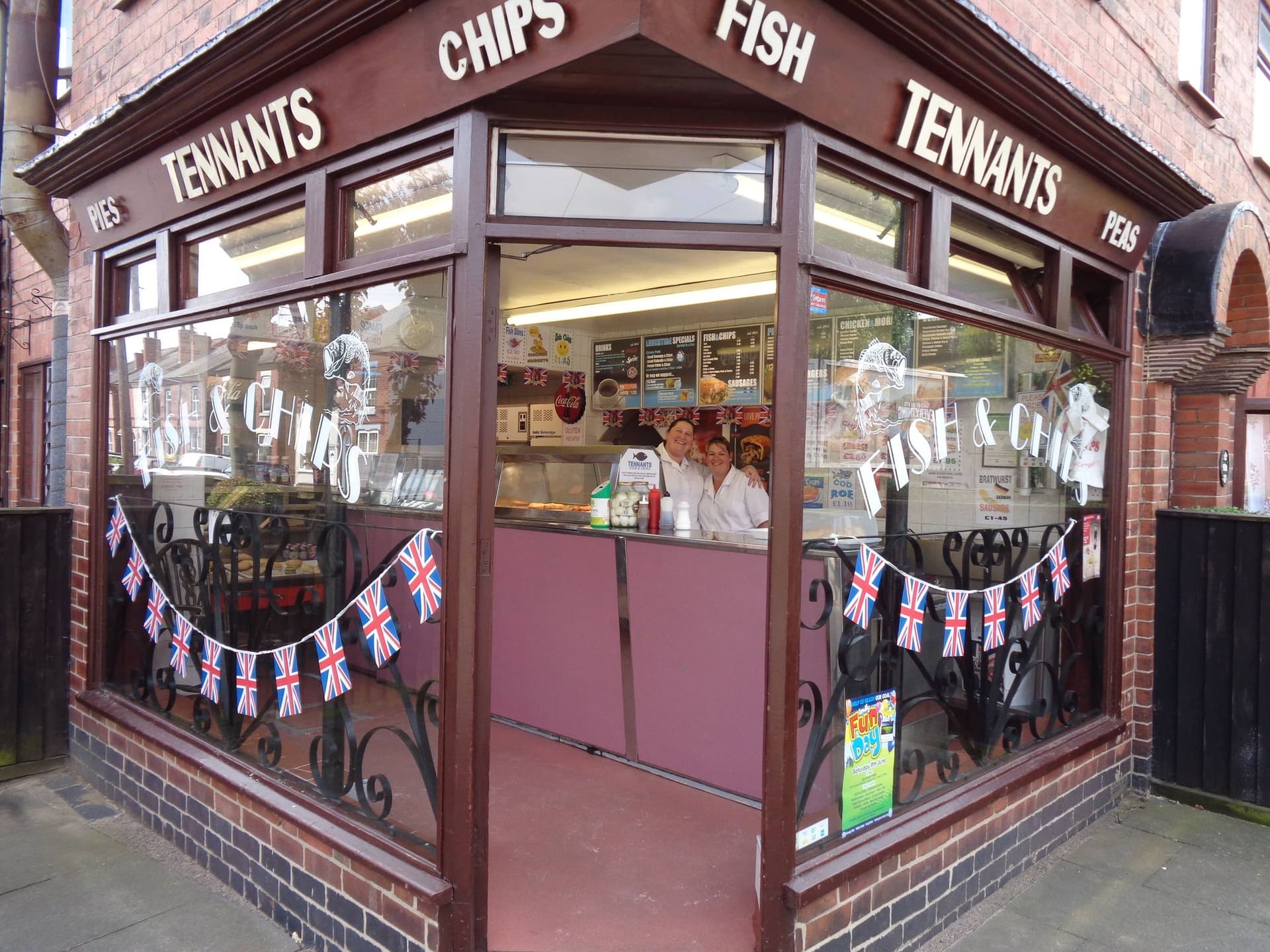 An external photo of Tennants Fish & Chips, with staff standing behind the counter.